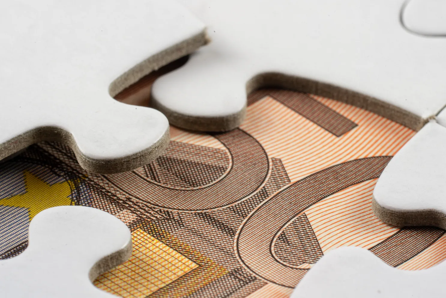 Prestiti fino a 20 milioni per le Mid-Cap il piano da 1,8 miliardi di CDP e UniCredit Puzzle bianco su una banconota da 20 euro, immagine simbolica dei finanziamenti per PMI e Mid-Cap